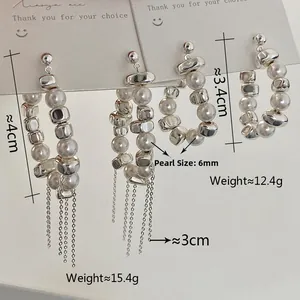 Detail of vintage luxury pearl earrings with silver tassels and irregular beaded design