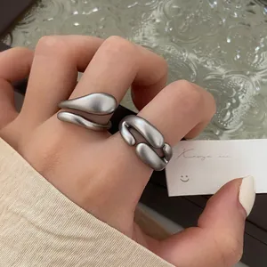 Detail der unregelmäßigen verstellbaren Ringe aus flüssigem Metall in Mattsilber