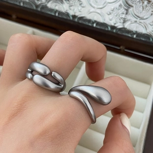 Nahaufnahme matter silberner Ringe mit unregelmäßigem flüssigem Metalldesign