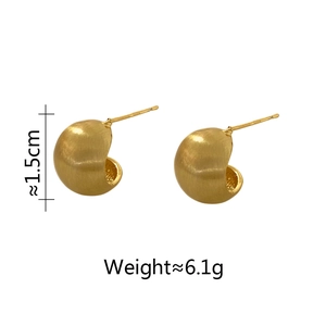 Détail macro de boucles d'oreilles dorées brossées montrant la taille de 1,5 cm