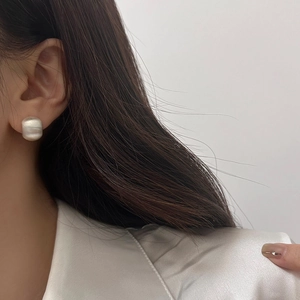 Detail of silver matte brushed finish earrings on model showing modern circular texture