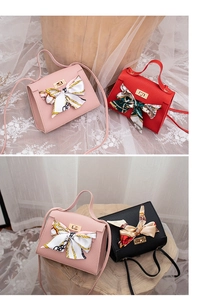 Detail of lychee pattern leather handbag with elegant silk scarf and metal twist lock
