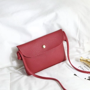 Chic red mini crossbody bag in lychee pattern faux leather with gold buckle detail