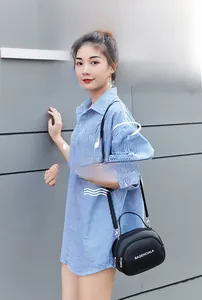 Outdoor shot of a black crossbody bag with white letter print and double zipper design