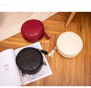 Quilted round crossbody bags with tassel detail in wine red, black, and beige colors