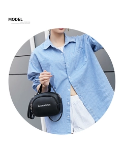 Close-up of black PU Boston bag with white logo lettering and adjustable shoulder strap