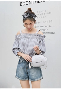 Close-up of white mini crossbody bag with letter print and adjustable shoulder strap