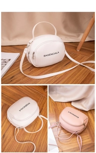 Detailed top view of compact round PU leather bags with dual zippers and logo print