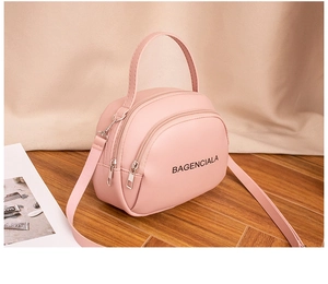 Close-up of pink mini crossbody bag with double zipper and BAGENCIALA lettering