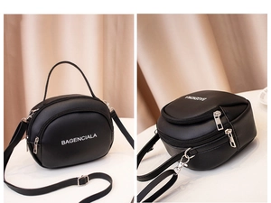 Detail of black mini crossbody bag with letter print and dual zipper compartments