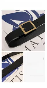 Detail of adjustable black pebble leather belt with a square gold metal buckle