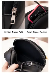Detail of black faux leather crossbody bag showing functional zippers and front pocket