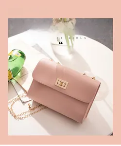 Detail of pink faux leather crossbody bag with lychee texture and golden metal twist lock