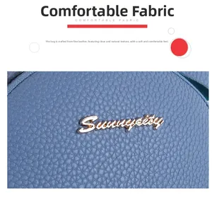 Detail shot of blue pebbled leather surface with metallic Sunneycity logo emblem