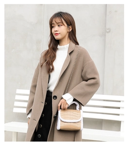 Close-up of light brown crocodile texture handbag with white plush trim and chain strap