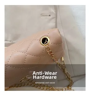 Detail of durable gold metal chain and quilted leather texture with anti-wear hardware