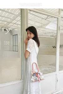 Detailed shot of transparent PVC tote bag with pink handles and a decorative silk scarf