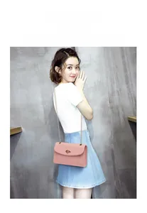 Gros plan sur un sac à bandoulière en cuir rose clair avec chaîne dorée et fermoir ovale