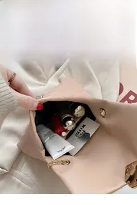 Internal view of pink quilted chain bag showing capacity for cosmetics and lipsticks