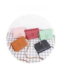 Detailed view of small rectangular crossbody phone bags in five assorted colors on a grid