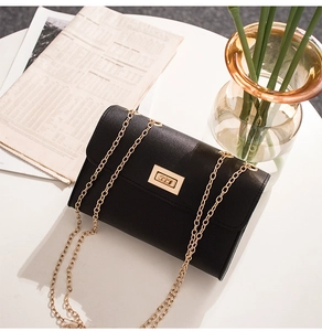 Close-up of black lychee grain leather crossbody bag with gold chain and turn-lock