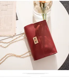Detail of burgundy textured leather bag with gold twist lock and chain strap