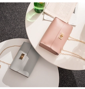 Close-up of minimalist PU leather chain bags with golden twist locks in pink and grey
