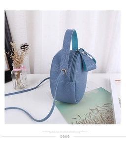 Close-up of blue round crossbody bag with litchi grain texture and sturdy handle