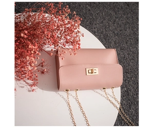 Detail of pink chain square bag with golden twist lock on white round stand