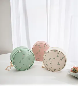 Tre borse tonde in menta, rosa e bianco con ricami floreali e catena metallica
