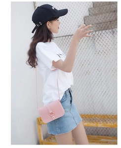 Detail view of pink mini crossbody bag with metal ring buckle on a casual model outfit