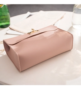 Close-up of pink pebbled leather crossbody bag with elegant golden turn-lock and chain
