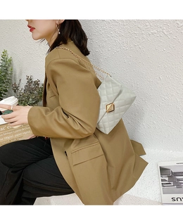 Side view of quilted crossbody bag with gold chain strap and square metal lock
