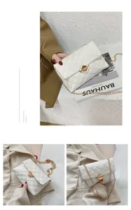 Detail of white quilted envelope bag with gold geometric clasp and metal chain strap