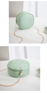 Dettaglio borsa rotonda verde menta con ricamo floreale e tracolla a catena dorata