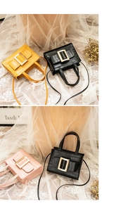 Close-up of mini crocodile pattern handbags in yellow, black and pink with gold buckles