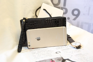 Pochette noire brillante à texture crocodile avec fermeture éclair et clous dorés
