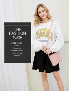 Bolso bandolera de cuero PU rosa con placa metálica mostrado en modelo con ropa casual