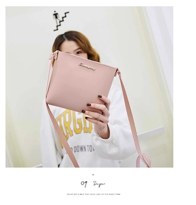Detalle del bolso bandolera de cuero rosa con emblema de logo de metal dorado