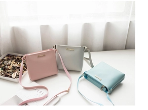 Bolsos bandolera minimalistas color macaron en rosa, azul y gris con logotipo dorado
