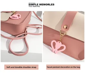 Detailed view of pink heart pendant and texture on small square crossbody phone bag
