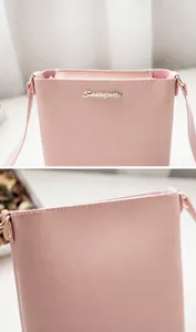 Detalle del bolso de hombro en cuero PU rosa con logo de metal dorado y textura fina