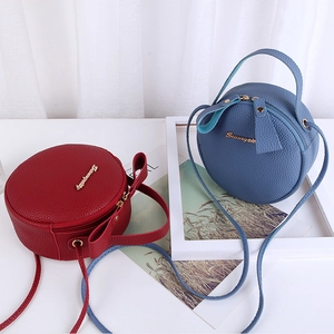 Litchi pattern round crossbody bag in red and blue colors with top handle and gold logo