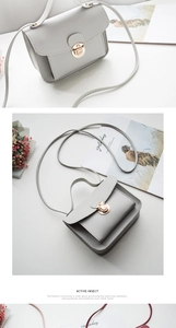 Close-up of elegant small square bag with golden lock clasp and textured leather