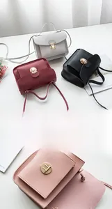 Close-up of the elegant round metal buckle and stitching on the mini crossbody bag
