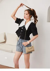 Détail du petit sac beige avec chaîne dorée assorti à une tenue d'été chic