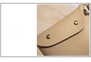 Vue détaillée du sac en cuir beige avec des rivets cylindriques dorés élégants