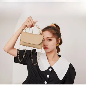 Sac à main chic en cuir beige avec poignée en acrylique et bandoulière dorée