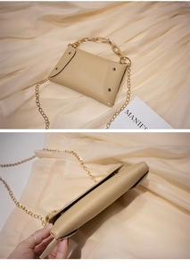 Vue détaillée du sac beige avec chaîne dorée et poignée en acrylique ambré