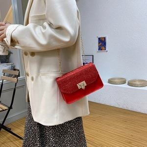 Chic red sequin crossbody bag with gold chain strap shown on model in stylish outfit